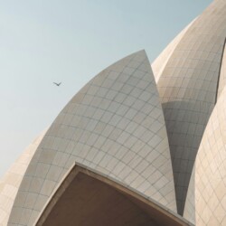 Looking up at the Lotus Temple's soaring petals showcases the innovative engineering behind this Bahá'í architectural marvel. Lotus Temple Delhi dramatic upward view of curved marble petals and geometric design