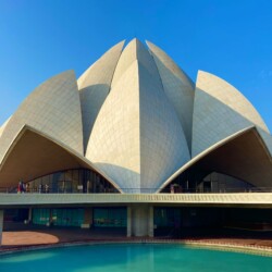 The Lotus Temple's marble petals create perfect reflections in the surrounding pools, enhancing the floating lotus effect. Lotus Temple Delhi white marble petals reflecting in surrounding water pool